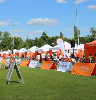 White and orange 6x3 gazebo with decorative pole cover tents and customised ING DiBa flags at sponsored sports event in Germany